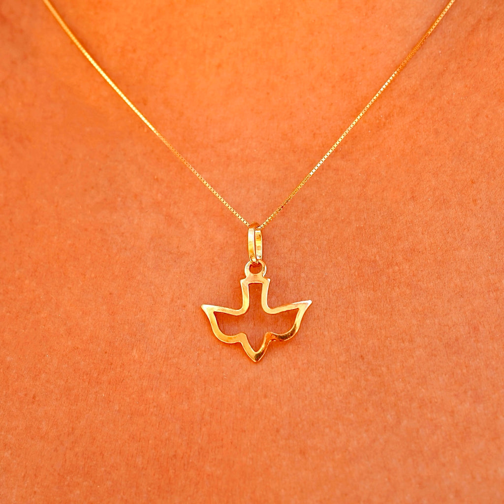 A model wearing the 14K solid gold Holy Spirit charm pendant on a delicate gold chain, showcasing the pendant's elegance and spiritual design as it rests gracefully on the model’s neck.