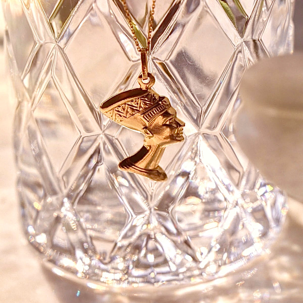 Close-up of a 14K Real Gold Nefertiti Charm, showcasing the detailed profile of the Egyptian queen, displayed on a plain background.