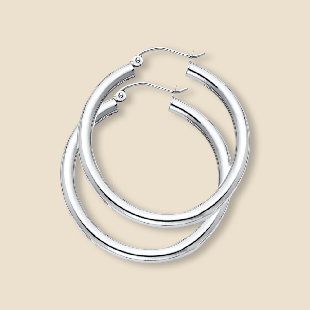 A pair of elegant 14K white gold hoop earrings in yellow gold, displayed against a plain background, showcasing their polished finish and timeless design.