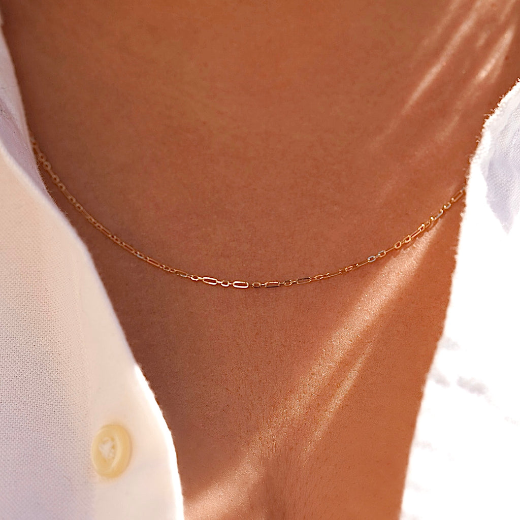 Model wearing a 14K gold 1.3mm chain, styled simply on the neck to show its everyday elegance and versatility.