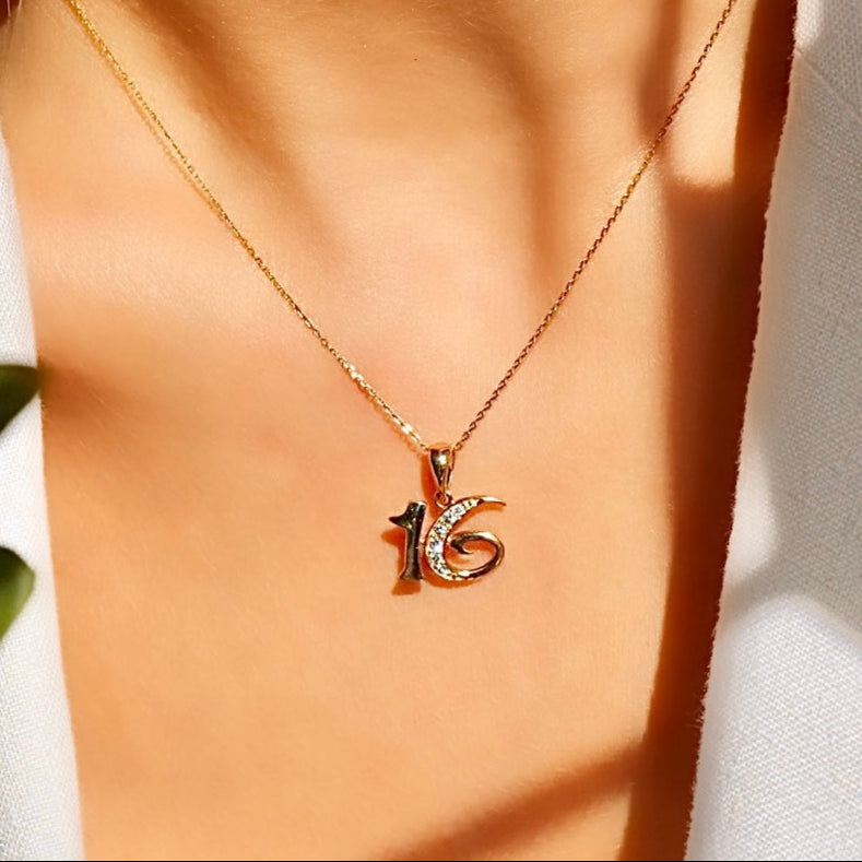 A model wearing the 14K Solid Yellow Gold Sweet 16 Pendant on a delicate gold chain, showcasing its dainty and meaningful design as a perfect birthday keepsake.