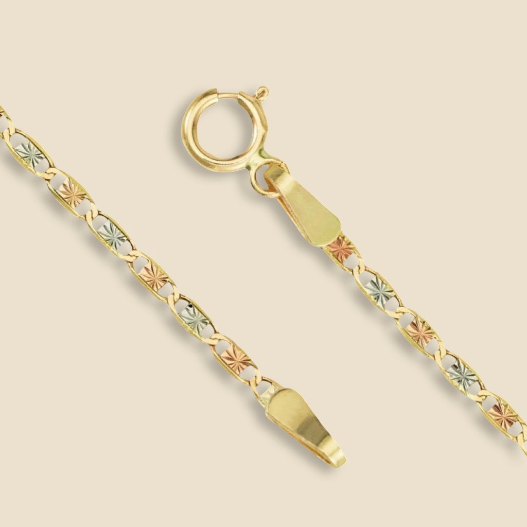 A 14K tri-color Valentino chain photographed on a plain background, clearly displaying the classic 1.5mm link pattern and luxurious gold tones.