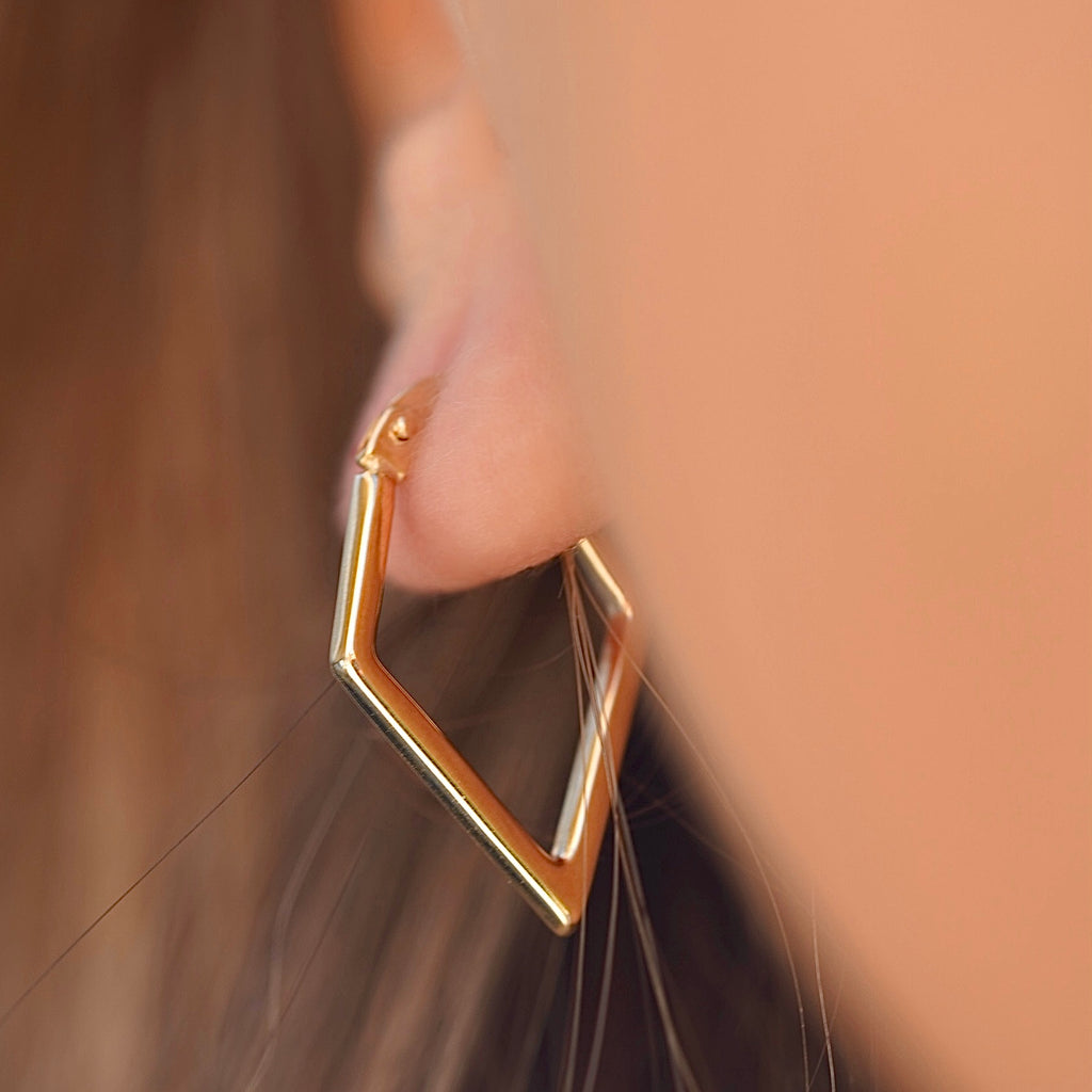Model wearing 14K gold diamond shape hoop earrings, showcasing the lightweight, modern design and elegant drop length.
