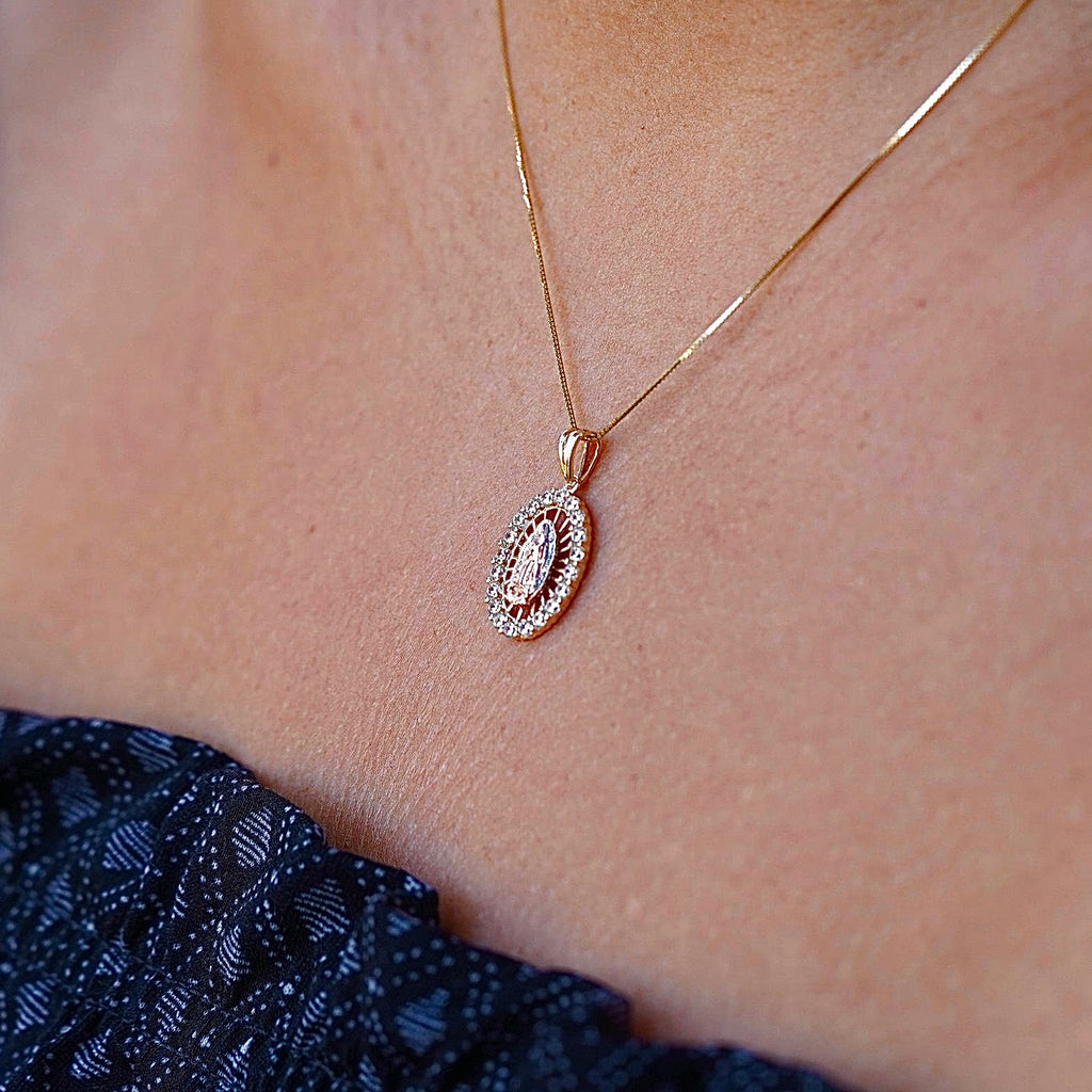 14K Gold Lady of Guadalupe Charm worn by a model, elegantly displayed on a delicate chain. The radiant gold finish and cubic zirconia accents shine beautifully, making it a perfect religious jewelry piece for everyday wear or special occasions.