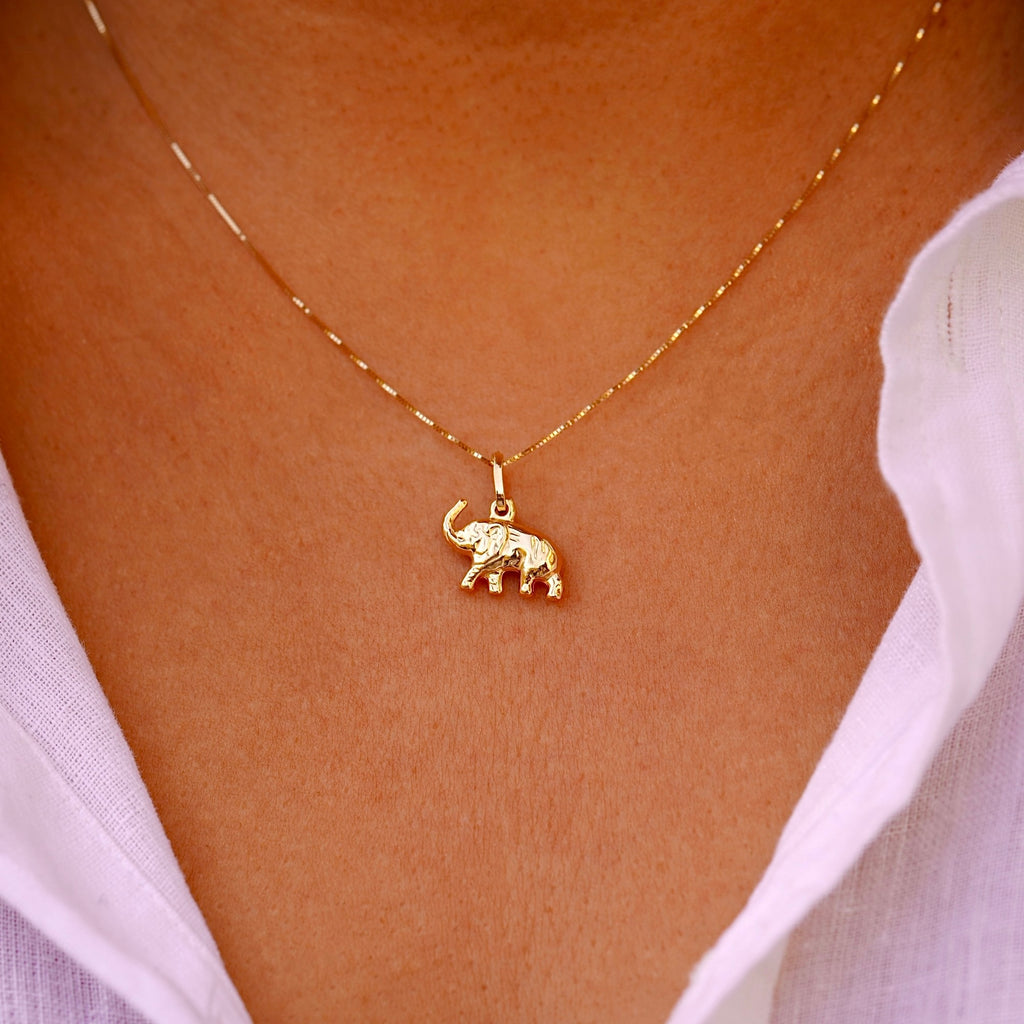 Model elegantly wears the 14K Gold Elephant Pendant on a delicate chain, highlighting its dainty size and sophisticated charm.