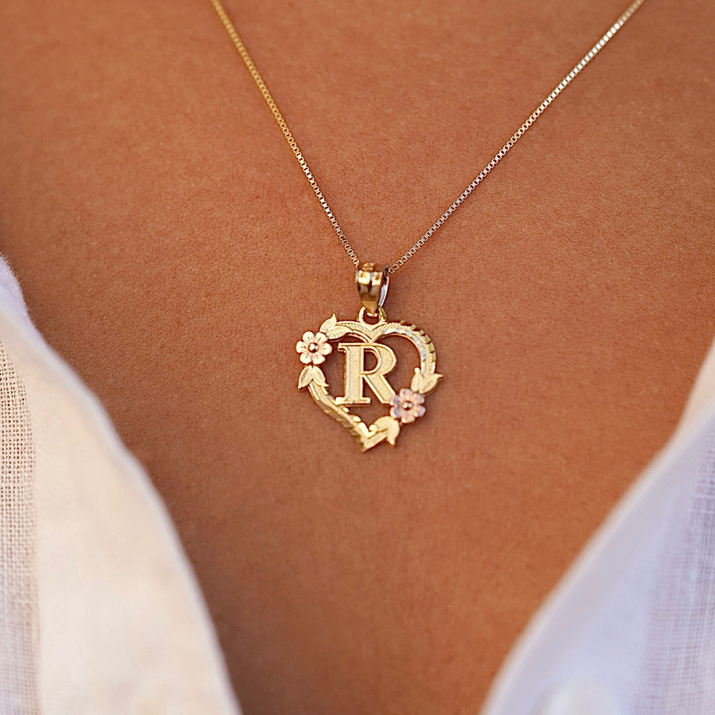 Model wearing the 14K Two-Tone Initial Heart Pendant with Letter R, highlighting the charm from the left side with elegant yellow and rose gold tones.
