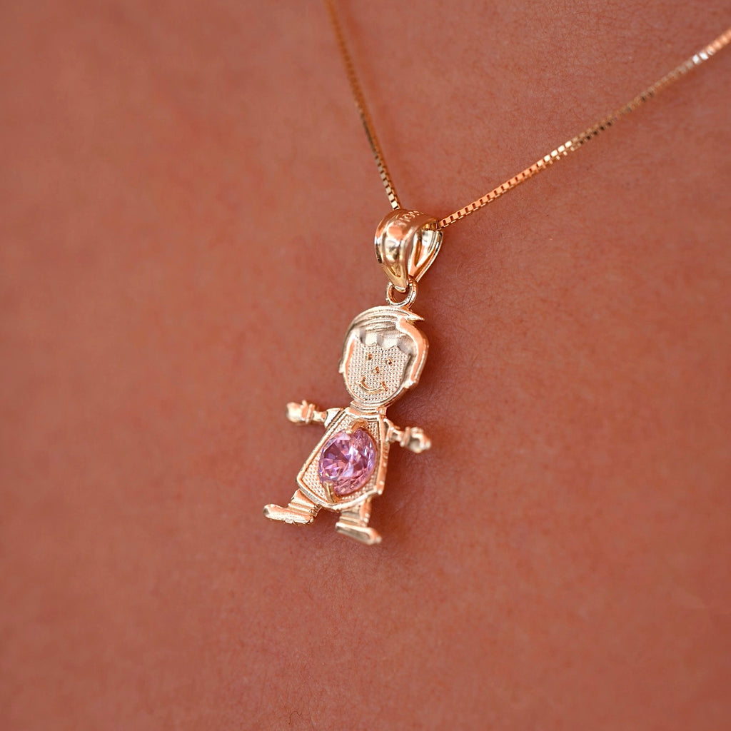 A model wearing the October birthstone boy charm on a delicate gold chain, showing how the 14K gold pendant sits lightly near the collarbone with the pink CZ sparkling subtly in the light.