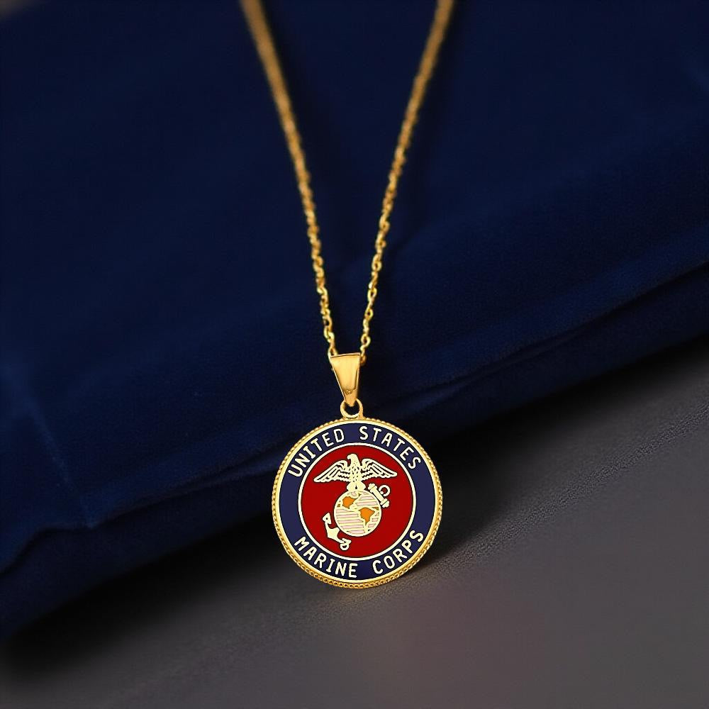 High-resolution close-up of a 14K Yellow Gold US Marine Corps pendant resting on navy blue fabric, highlighting the detailed emblem and craftsmanship.