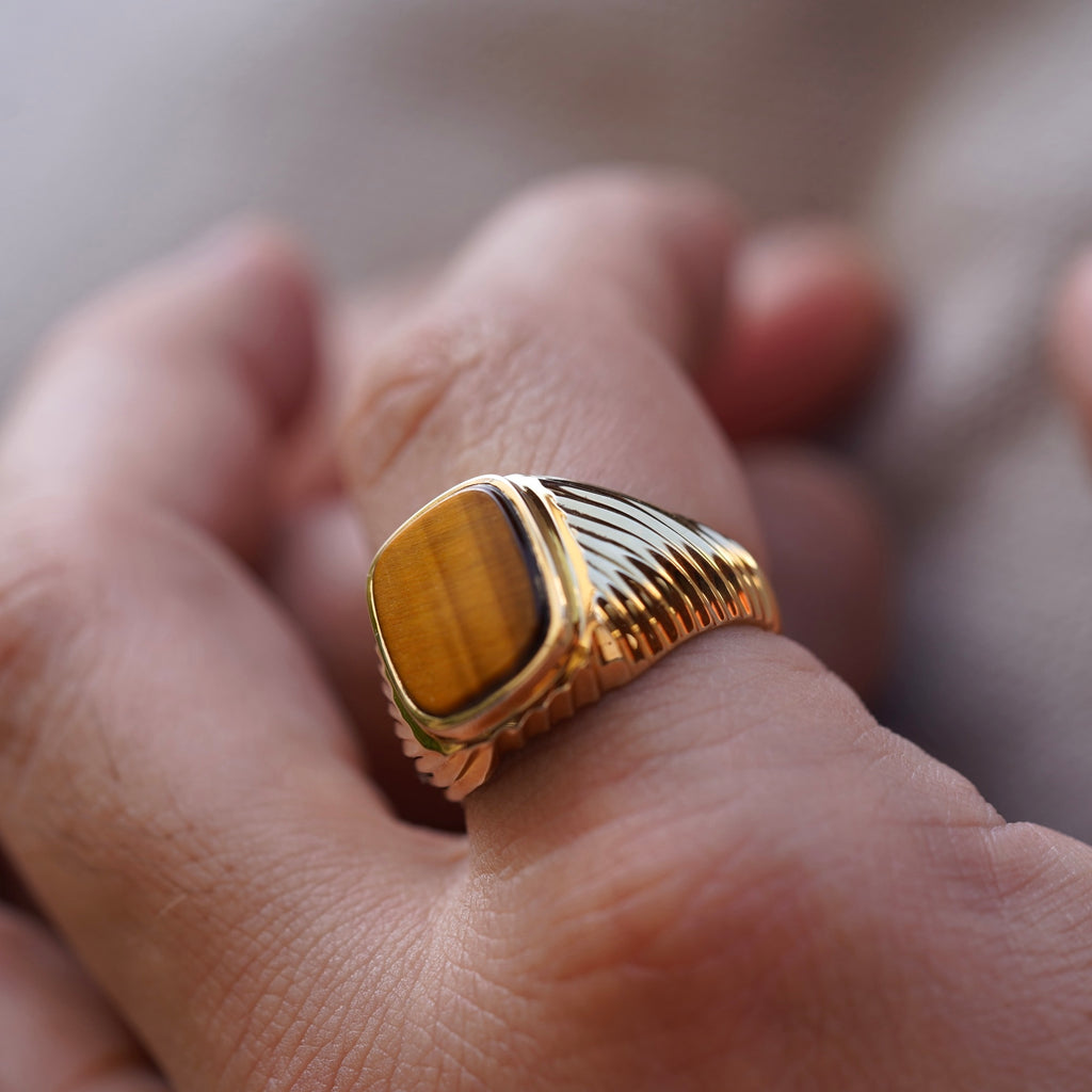 A sophisticated men's 14K gold ring with a 18mm width, worn on a model's hand. The polished yellow gold reflects light, adding elegance and confidence to any look.