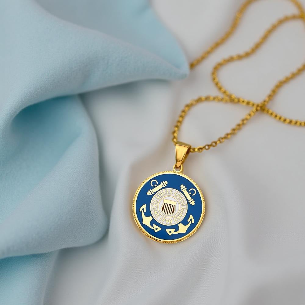 14K Gold US Coast Guard Pendant displayed on soft off-white and blue fabric, highlighting its high-polish finish and double-sided emblem design.