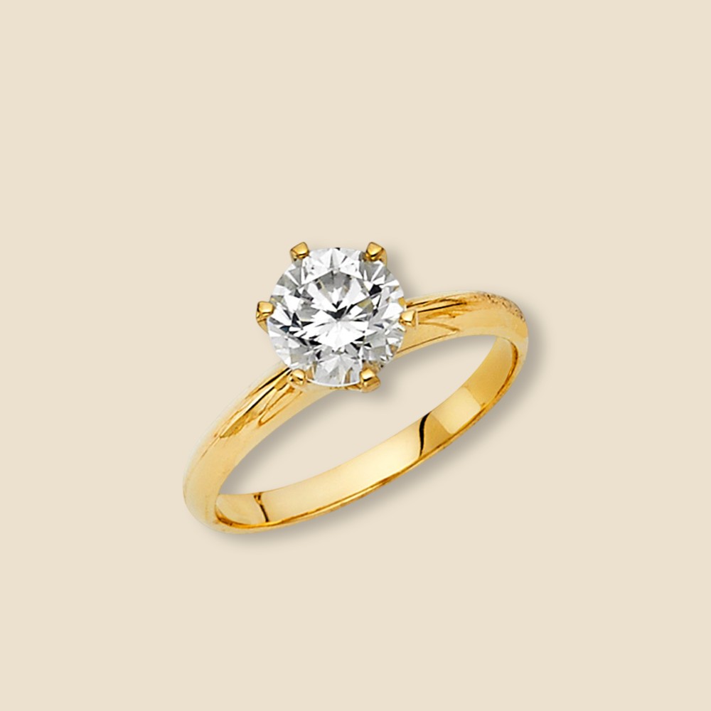 Close-up of a 14K yellow gold CZ engagement ring on a plain background, highlighting the band’s dual-tone detail and sparkling stone.