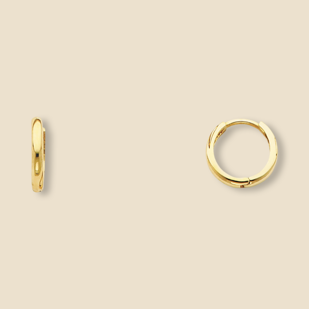 A pair of small 14K yellow gold Huggies earrings shown against a plain backdrop, revealing the sleek curvature and 10mm diameter of each hoop.
