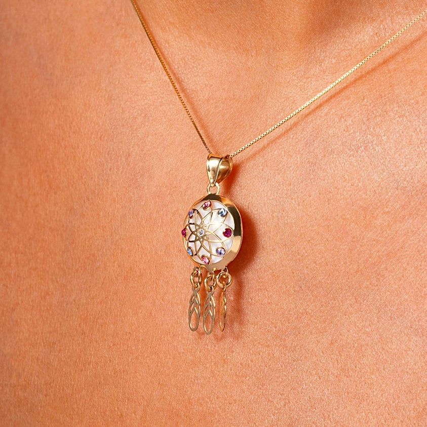 Model wearing a 14K gold dreamcatcher pendant on a fine chain, demonstrating its dainty size, everyday wearability, and bohemian-inspired style.