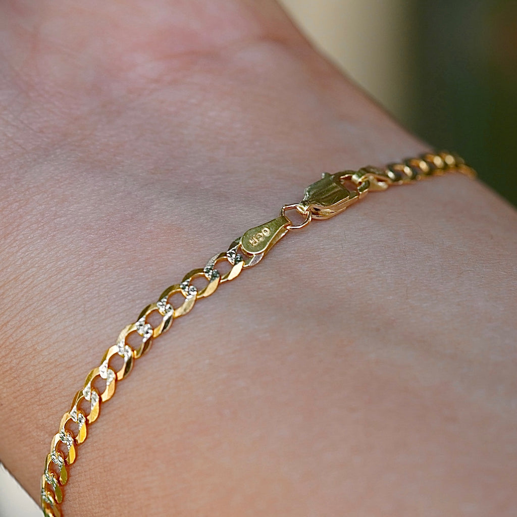 A model wearing the 3.2mm 14K Gold Cuban Link Bracelet with a white pave design, showcasing its elegant shine.