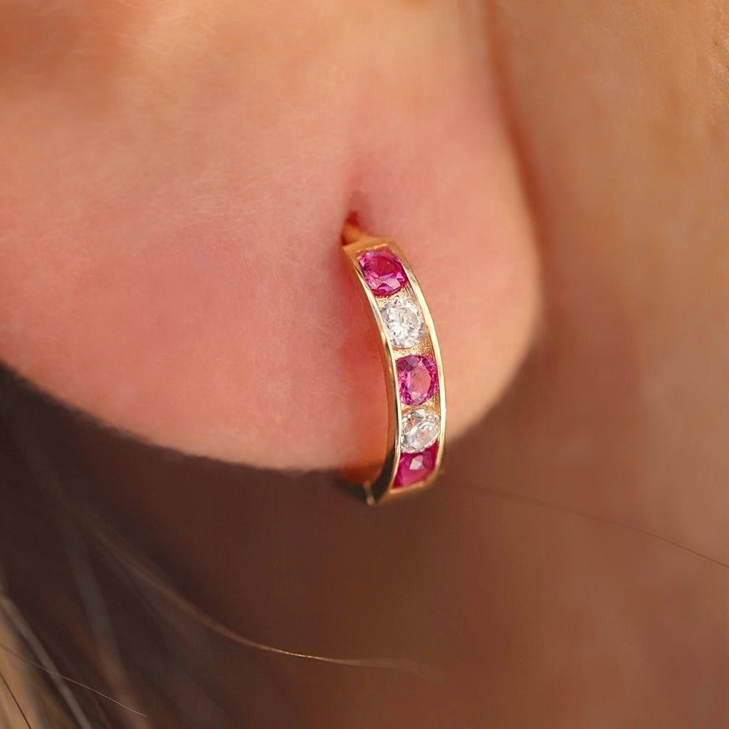 A stylish model wearing 14K Gold CZ Channel Set Hoop Huggies Earrings, showcasing their dainty size and elegant sparkle for everyday wear.