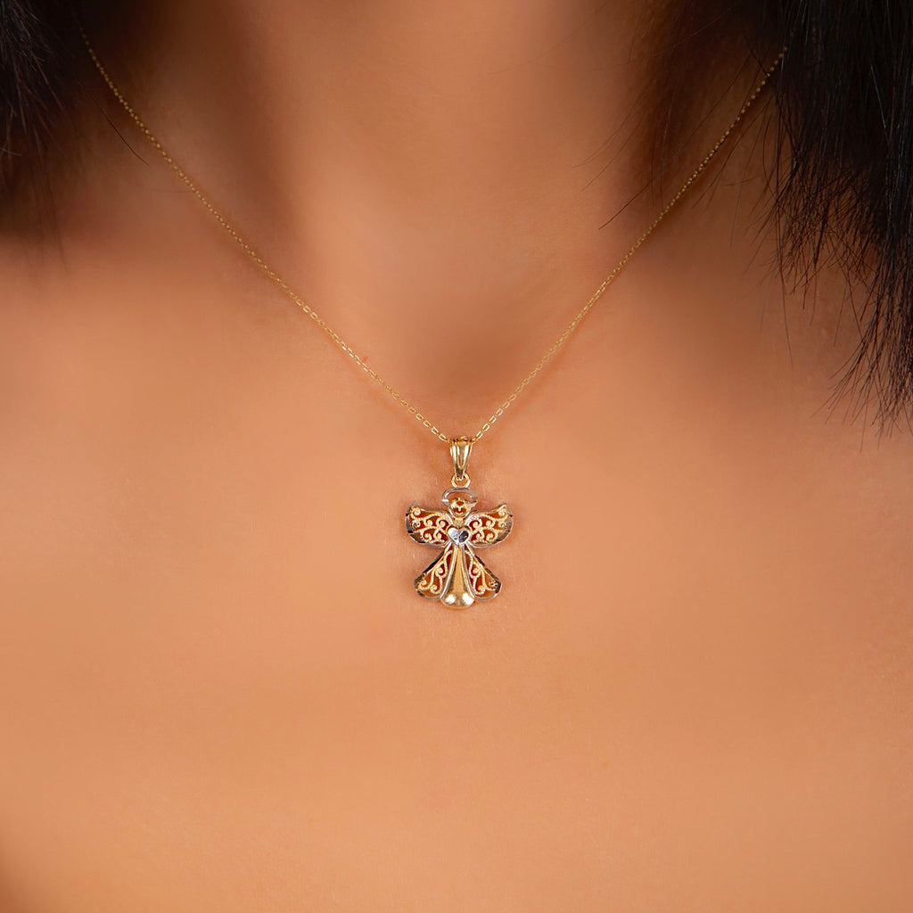 A woman wearing the 14K Gold Two-Tone Angel Charm on a delicate gold chain, highlighting its elegant shine and symbolic beauty against her neckline.
