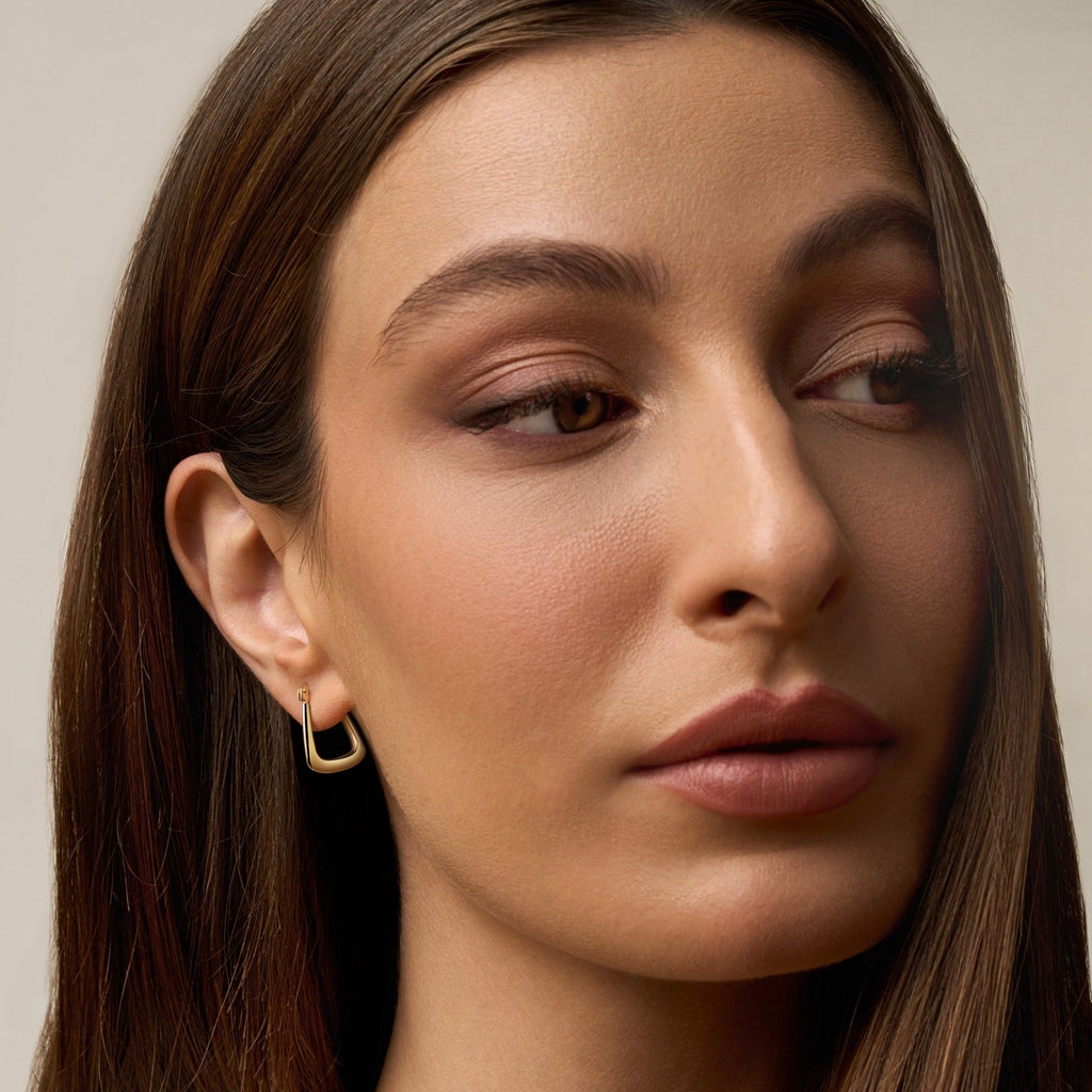 Model wearing 14K Yellow Gold Hollow Hoop Earrings, highlighting their lightweight, polished design and classic hoop style.