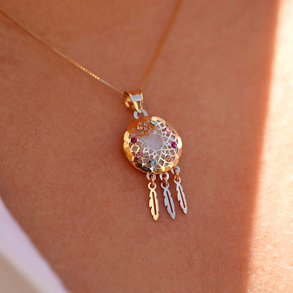 Model wearing a 14K yellow gold dreamcatcher pendant on a fine chain, the charm resting near the neckline, adding a touch of meaningful elegance and boho-inspired style.