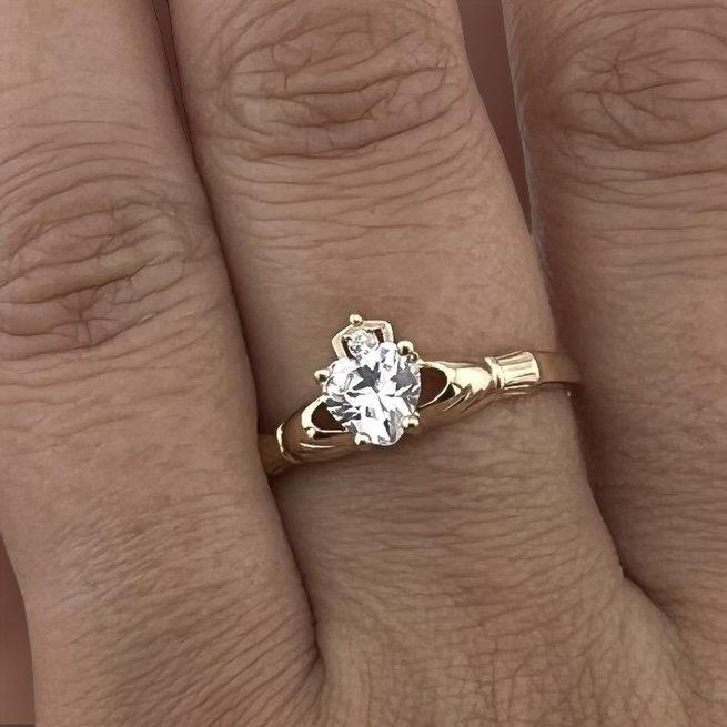 A model wearing a 14K Yellow Gold Claddagh Ring with Cubic Zirconia on her finger, highlighting its elegant design and symbolic meaning in a stylish everyday look.