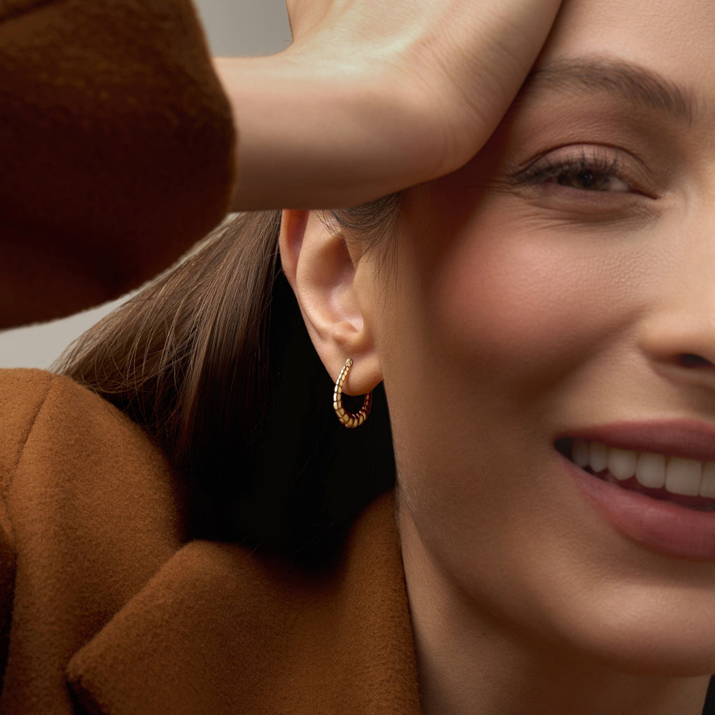 Model wearing 14K Yellow Gold Fancy Hollow Hoop Earrings, showing their elegant shine and comfortable lightweight design.