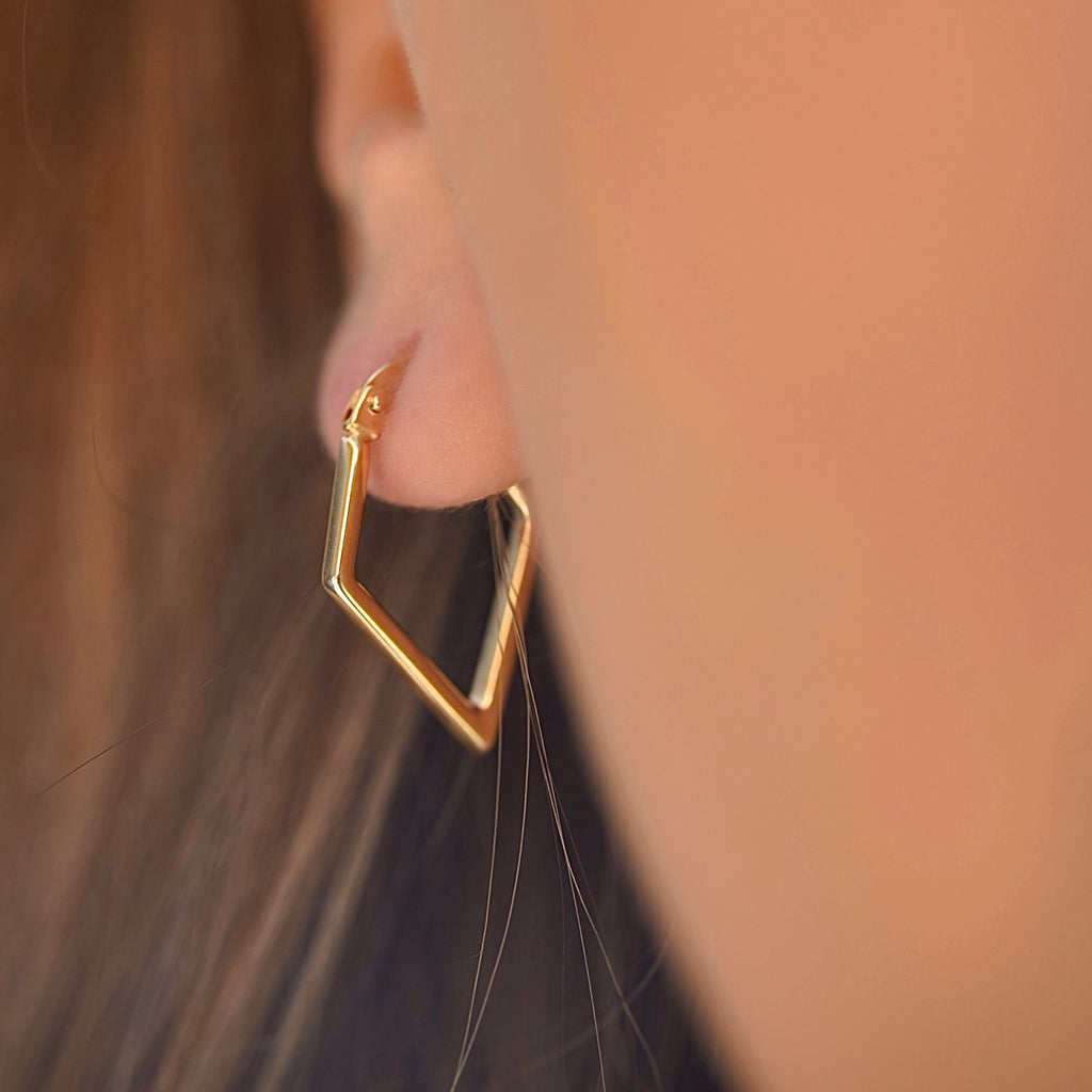 Model wearing 14K gold diamond shape hoop earrings, showcasing the lightweight, modern design and elegant drop length.