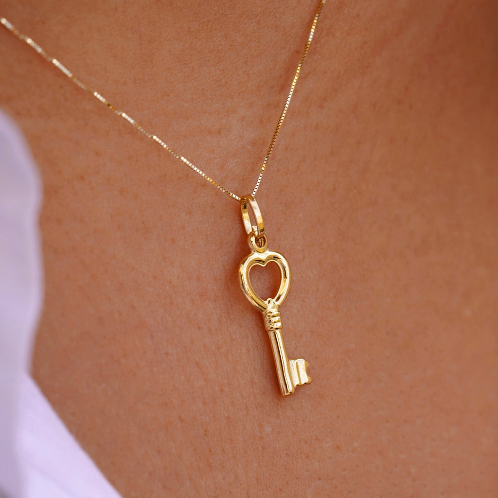A fashionable model elegantly wearing the 14K Real Gold Key Pendant on a gold chain, showcasing its timeless charm and sophisticated style.