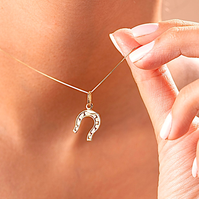 Model wearing the 14K Solid Gold Horseshoe Charm on a delicate gold chain, showcasing the charm's elegant design and symbolic meaning of good fortune.
