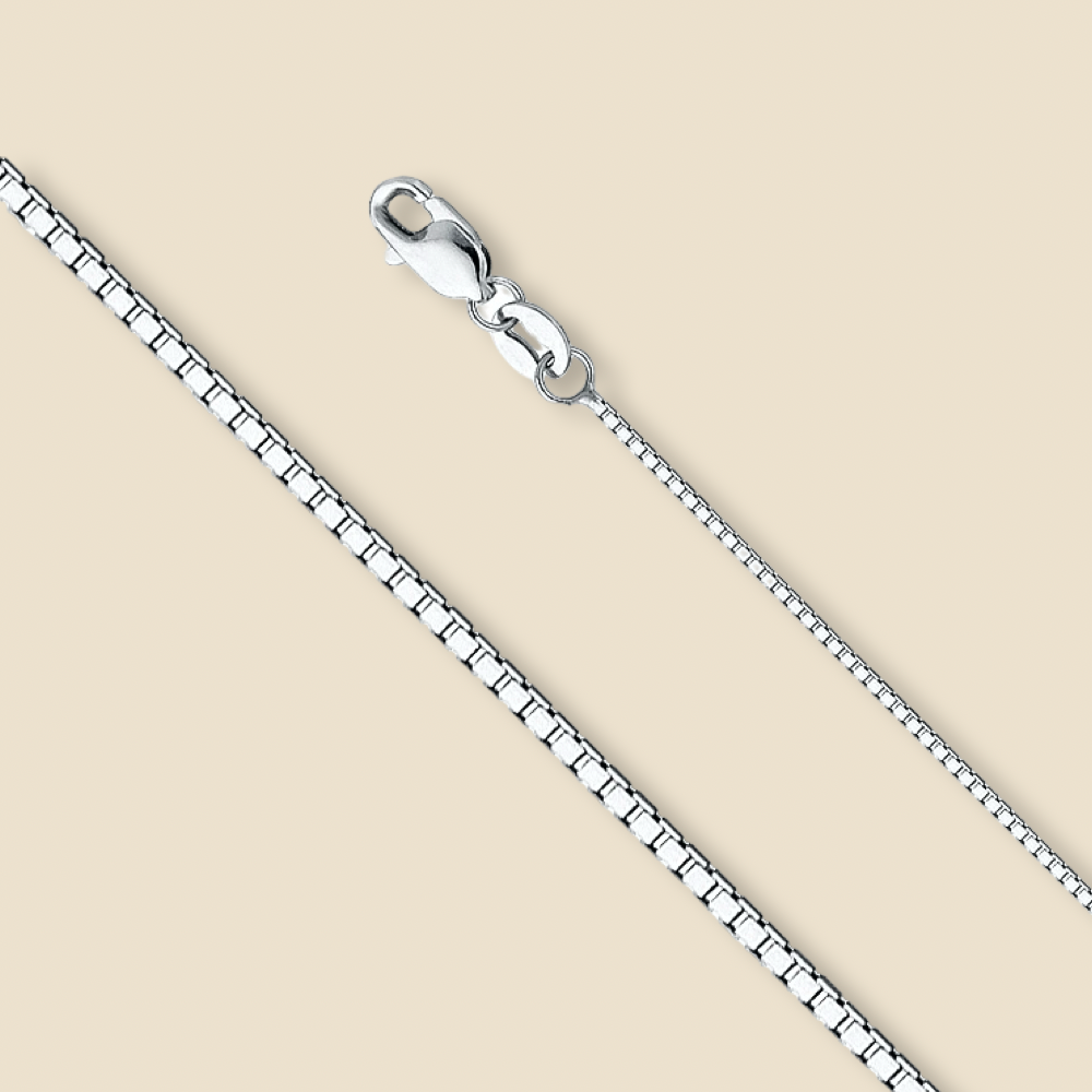 Studio image of a 14K gold box chain in white, laid straight on a plain background to emphasize its sleek 0.8mm design.