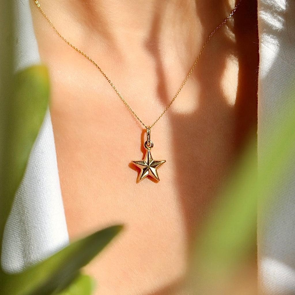 A stylish woman wearing the 14K solid gold starfish charm on a dainty chain, adding a subtle touch of ocean-inspired elegance to her summer outfit.