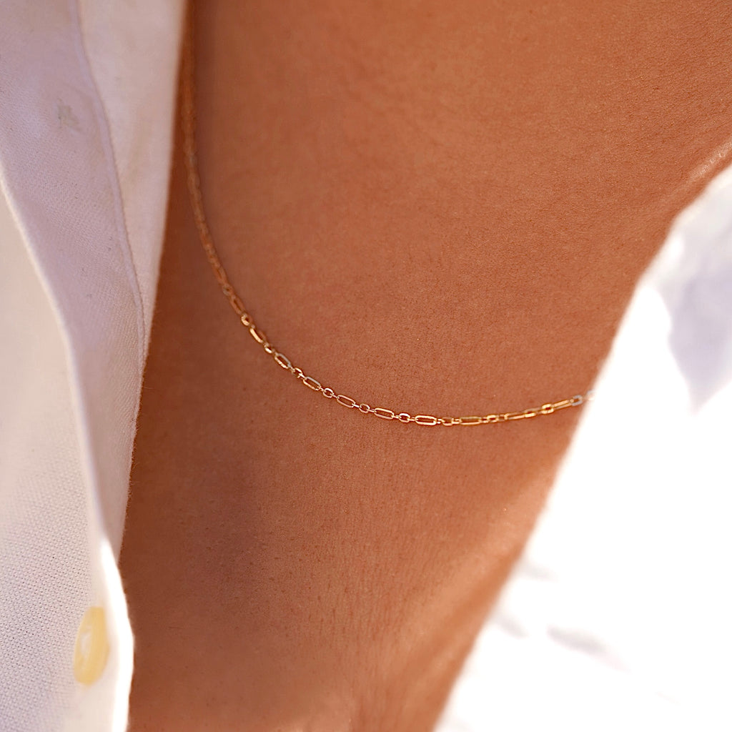 Model wearing a 14K gold 1.3mm chain, styled simply on the neck to show its everyday elegance and versatility.