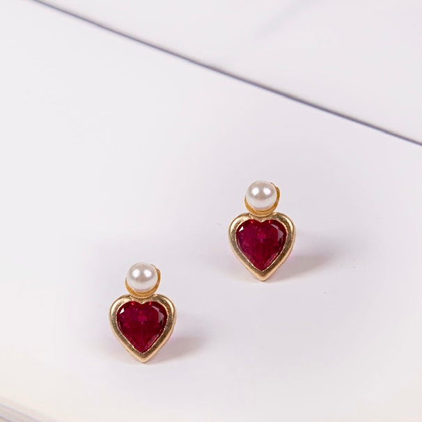 A close-up image of the 14K Gold Heart CZ & Pearl Earrings against a plain white background, showcasing their delicate heart-shaped cubic zirconia and luminous pearl set in polished yellow gold.
