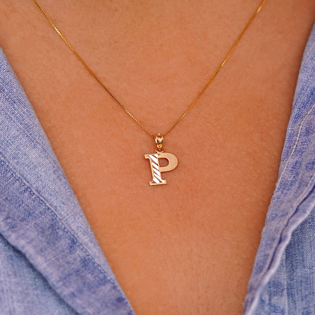 Model wearing a delicate 14K gold Initial P pendant necklace, layered with other fine chains for a personalized style statement.