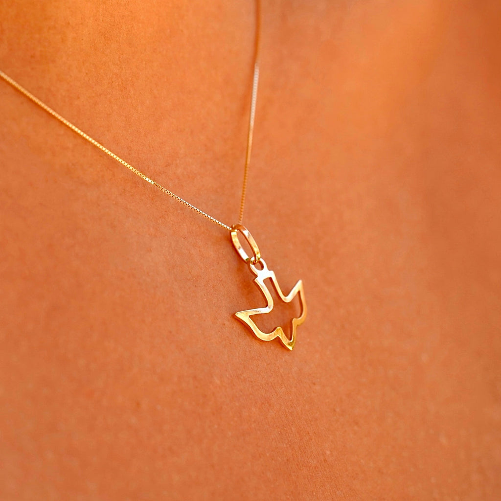 A model wearing the 14K solid gold Holy Spirit charm pendant on a delicate gold chain, showcasing the pendant's elegance and spiritual design as it rests gracefully on the model’s neck.
