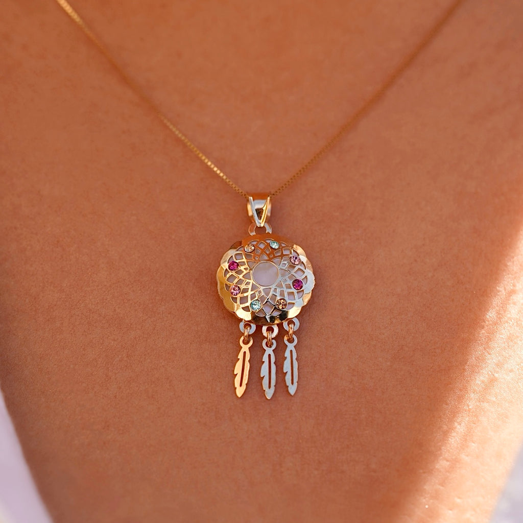 Model wearing a 14K yellow gold dreamcatcher pendant on a fine chain, the charm resting near the neckline, adding a touch of meaningful elegance and boho-inspired style.