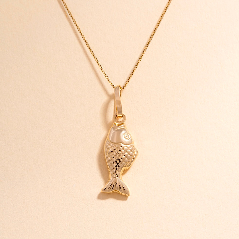 A close-up of the 14K Gold Fish Charm Pendant against a plain background, showcasing its polished gold finish and intricate detailing.