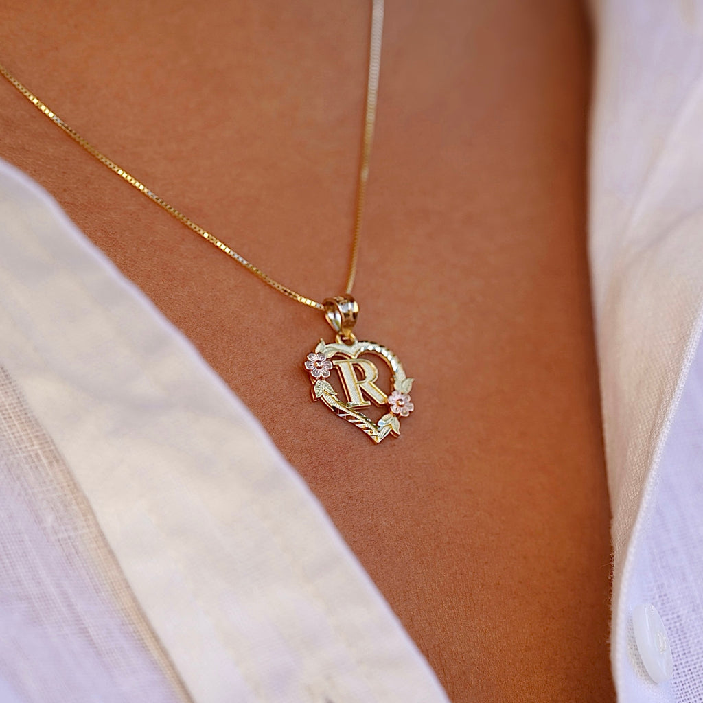 Model wearing the 14K Two-Tone Initial Heart Pendant with Letter R, highlighting the charm from the left side with elegant yellow and rose gold tones.