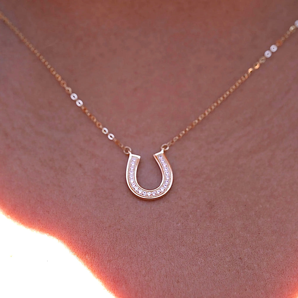 A model gracefully wears the 14K Solid Gold Horseshoe Necklace, showcasing its dainty and elegant design. The polished horseshoe pendant rests beautifully against the collarbone, adding a touch of luck and sophistication to any outfit. Perfect for layering or wearing alone as a meaningful statement piece.