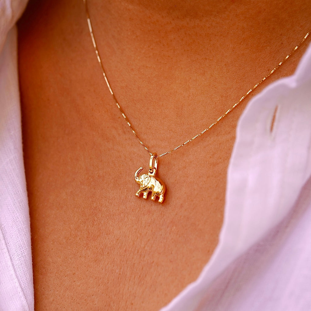 Model elegantly wears the 14K Gold Elephant Pendant on a delicate chain, highlighting its dainty size and sophisticated charm.
