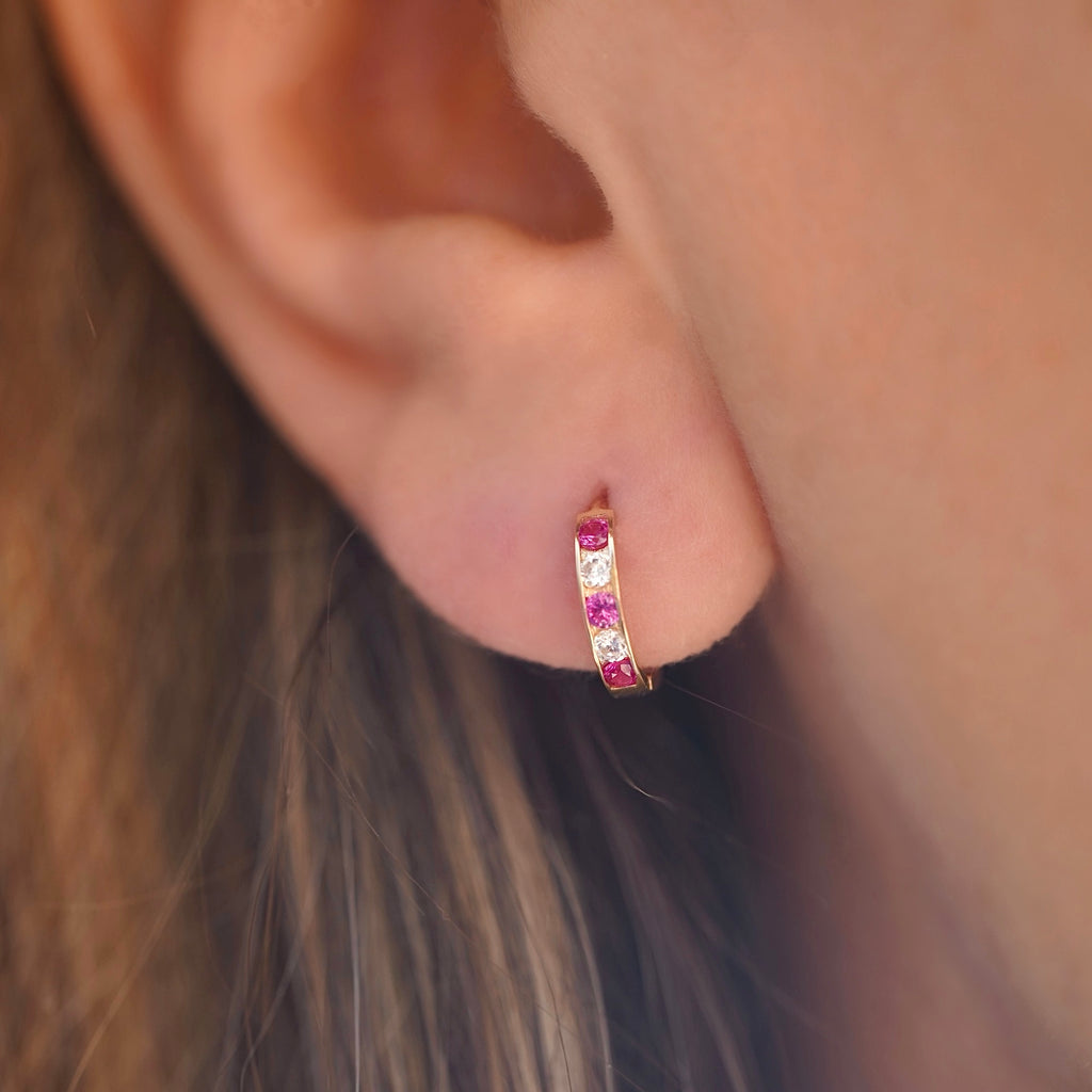 A stylish model wearing 14K Gold CZ Channel Set Hoop Huggies Earrings, showcasing their dainty size and elegant sparkle for everyday wear.