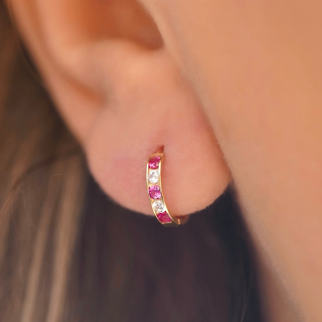 A stylish model wearing 14K Gold CZ Channel Set Hoop Huggies Earrings, showcasing their dainty size and elegant sparkle for everyday wear.