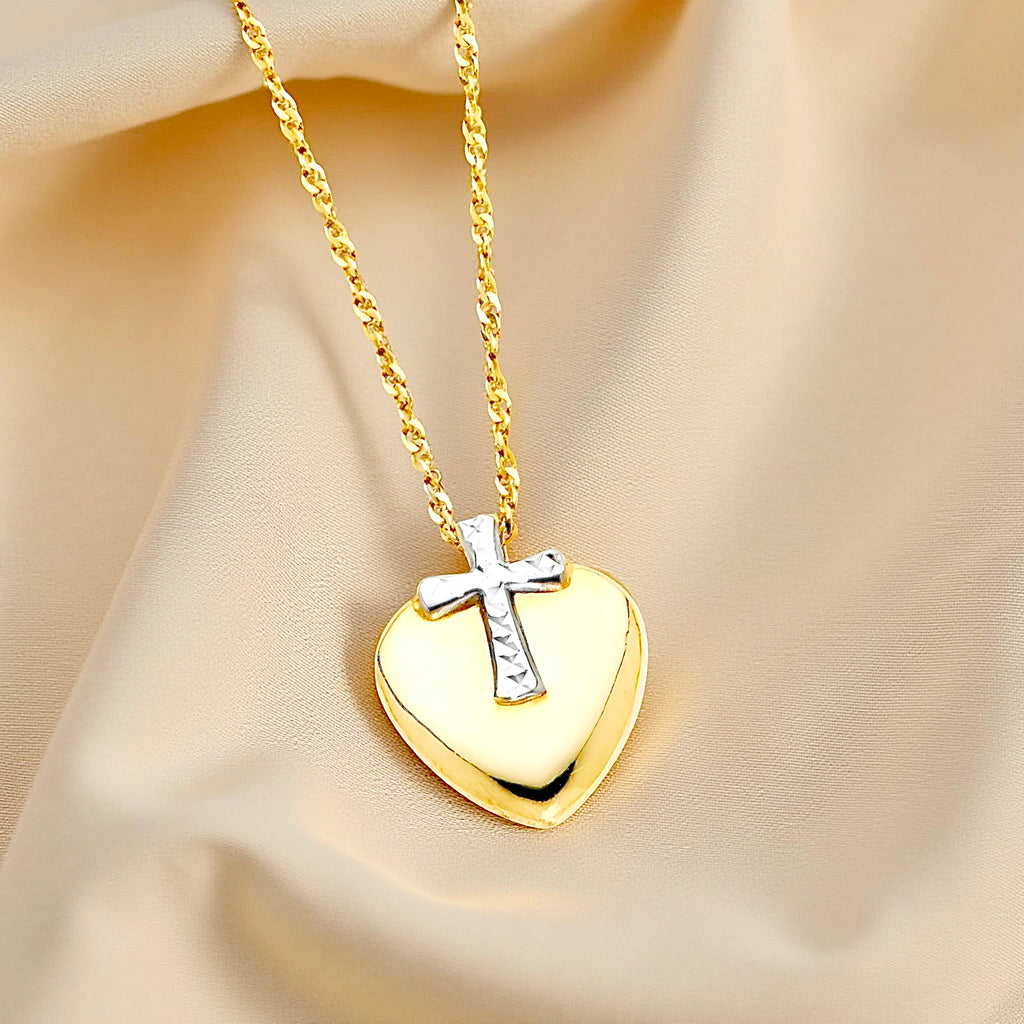 Elegant 14K gold heart intertwined with a cross pendant resting on neutral textured cloth, capturing a sense of grace and devotion.