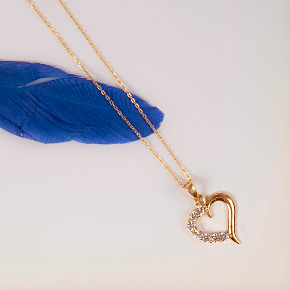 14K Solid Yellow Gold Tiny Heart Charm featuring a polished finish and a sparkling cubic zirconia gemstone, displayed against a plain background to showcase its dainty and timeless design.