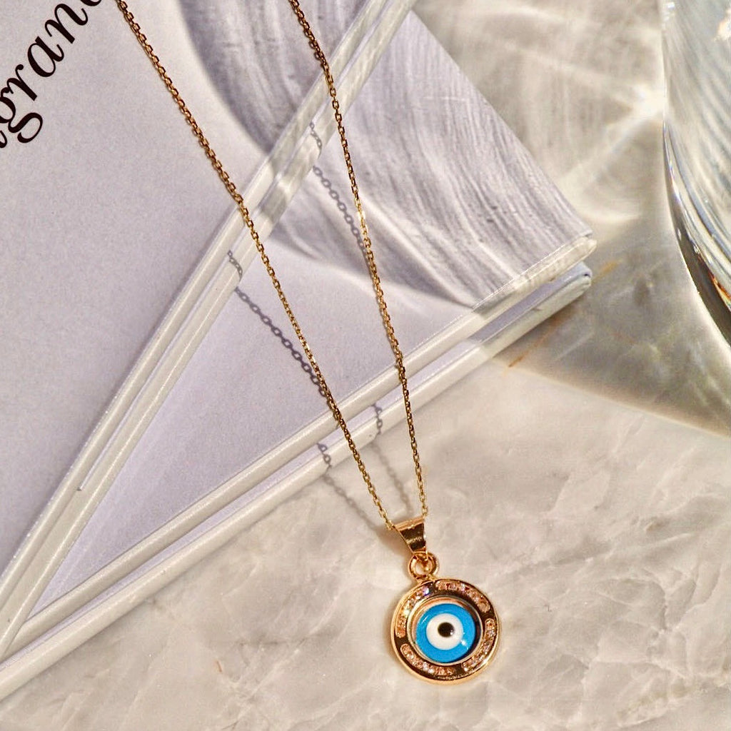 14K Yellow Gold Evil Eye Charm Pendant displayed against a plain background, showcasing its intricate detailing and polished finish.