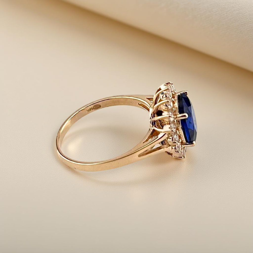 Side view of the 14K gold blue CZ engagement ring, showcasing the smooth, polished band and detailed stone setting in yellow.