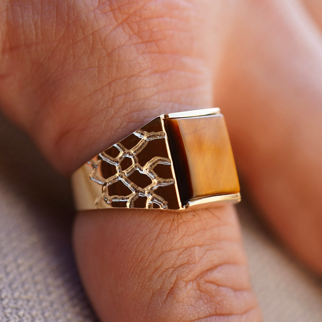 A sophisticated men's 14K gold ring with a 19mm width, worn on the hand of a model. The polished yellow gold catches the light, adding a touch of elegance and confidence to any outfit.