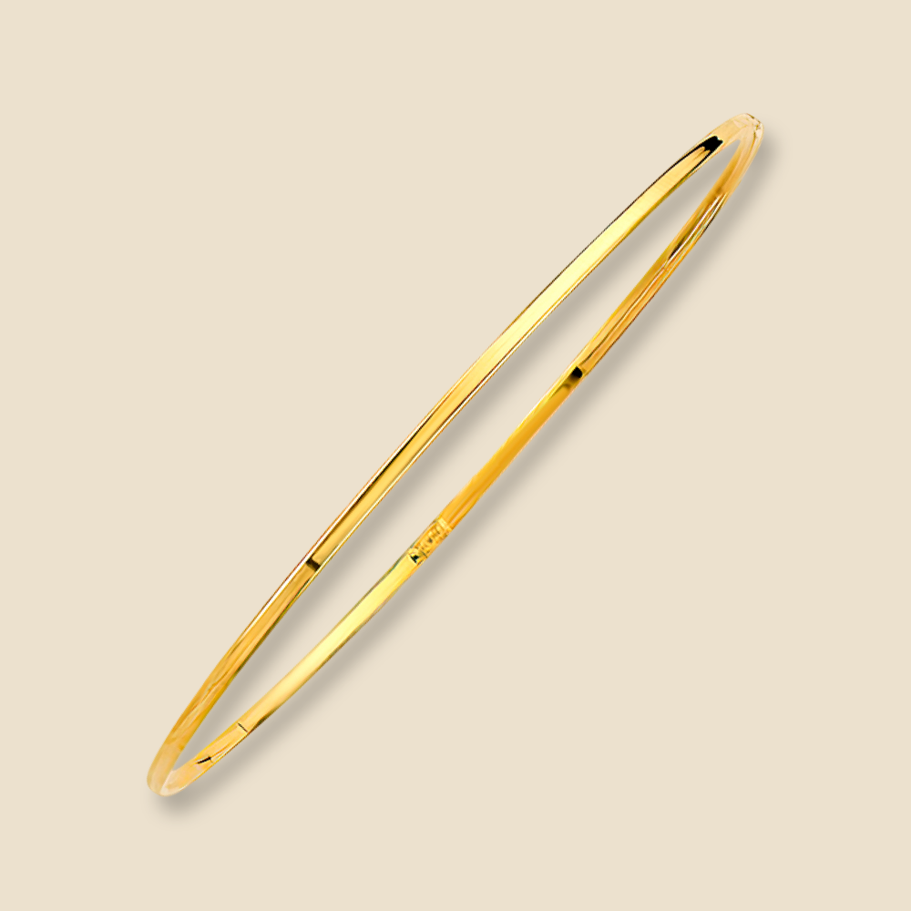 A 14K yellow gold plain bangle bracelet with a slim 1.5mm width shown on a plain background, reflecting light off its polished gold surface.