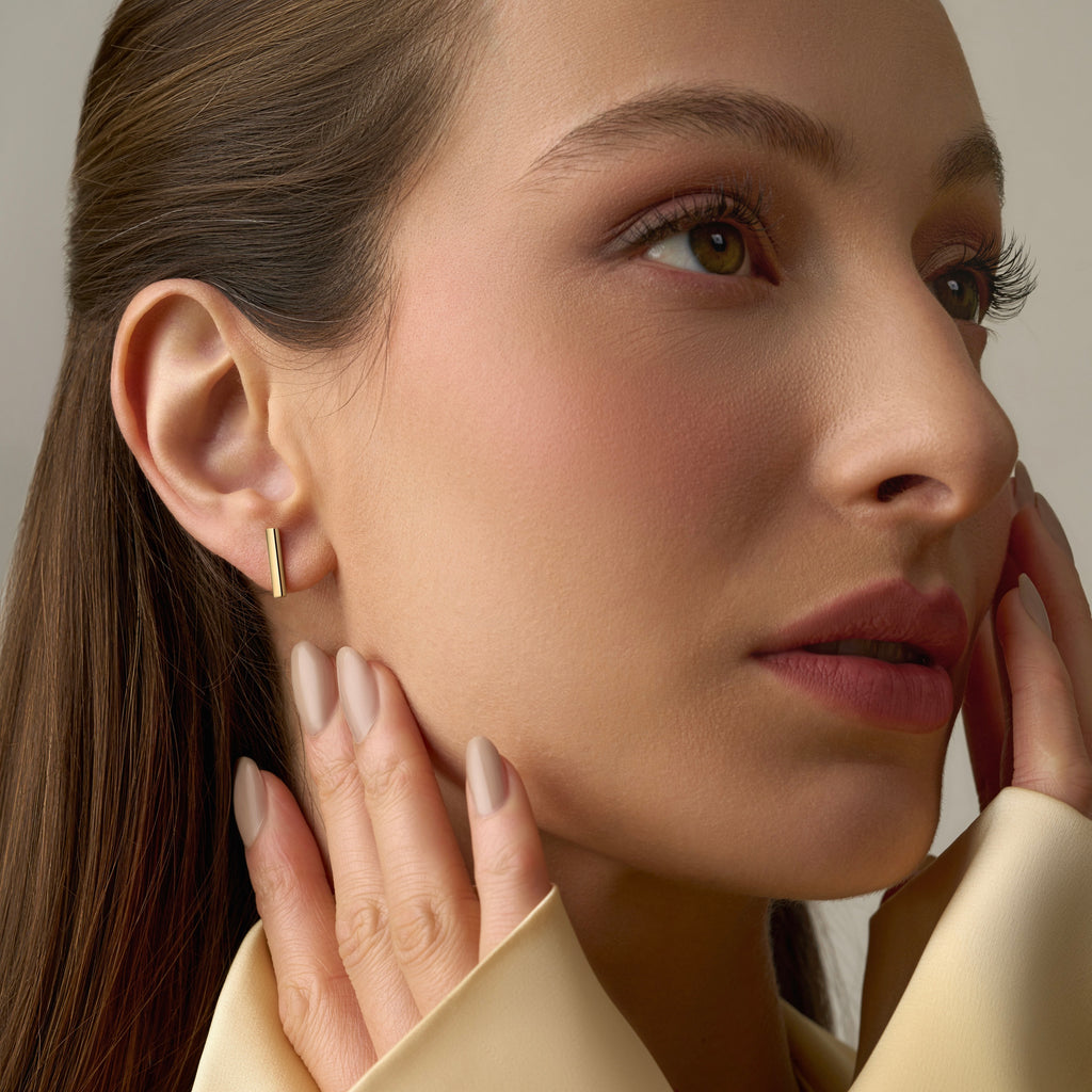 Model wearing 14K Yellow Gold Little Bar Earrings, highlighting their sleek minimalist design and secure push-back closures.