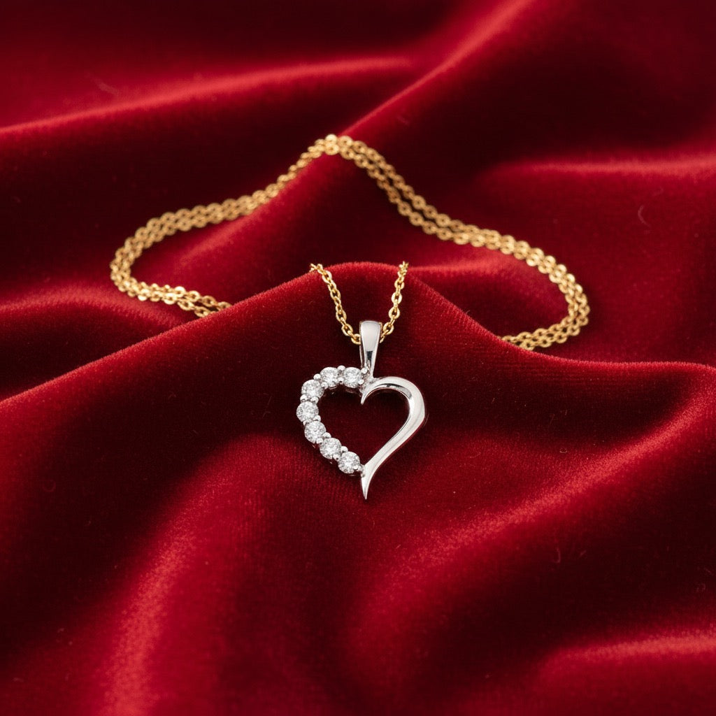14K White Gold CZ Heart Pendant with Yellow Gold Chain laying on red velvet background.