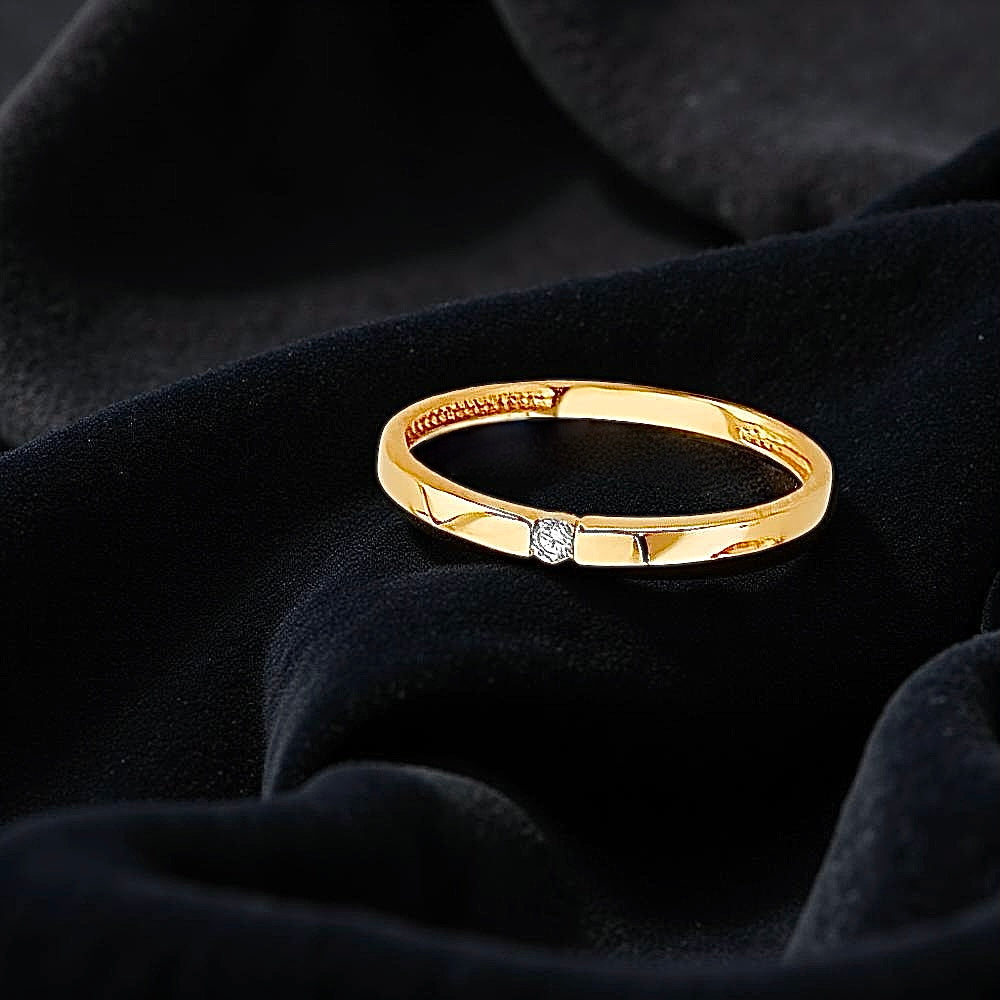 Dainty 14K yellow gold CZ ring resting on a black velvet cloth, highlighting its elegant sparkle and minimalist design.