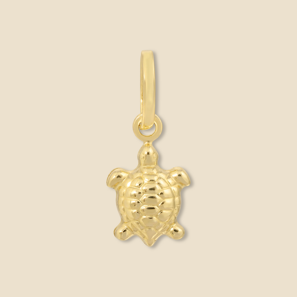 Close-up of a 14K gold turtle pendant on a plain background, showcasing its delicate craftsmanship, polished finish, and intricate details.